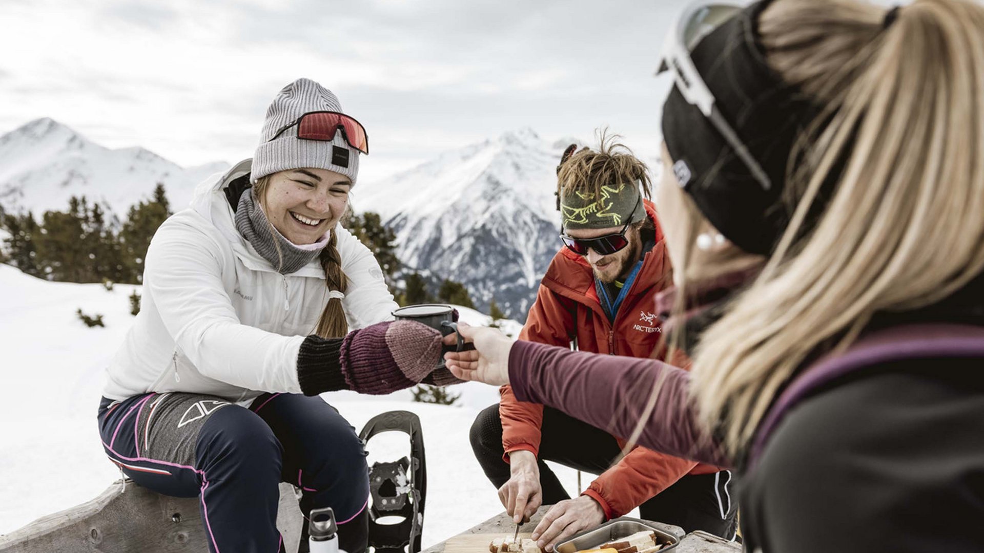 Winterurlaub in Tirol – Skispaß & Entspannung in den Alpen Freunde genießen eine Winterpause mit Essen und Getränken in den verschneiten Bergen