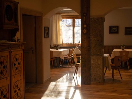Alpine Kulinarik in Prutz Gemütlicher Essbereich mit Holzmöbeln und Tageslicht durch Fenster