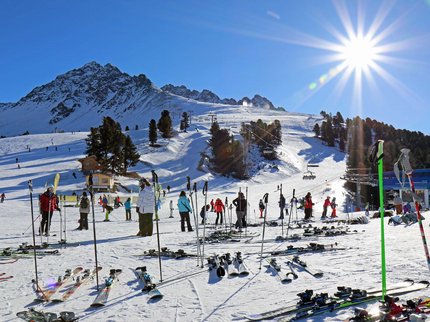 Hotel Post: Ihr Skihotel in Tirol Sonniger Skitag mit Skifahrern und Skiern an einem Berghang