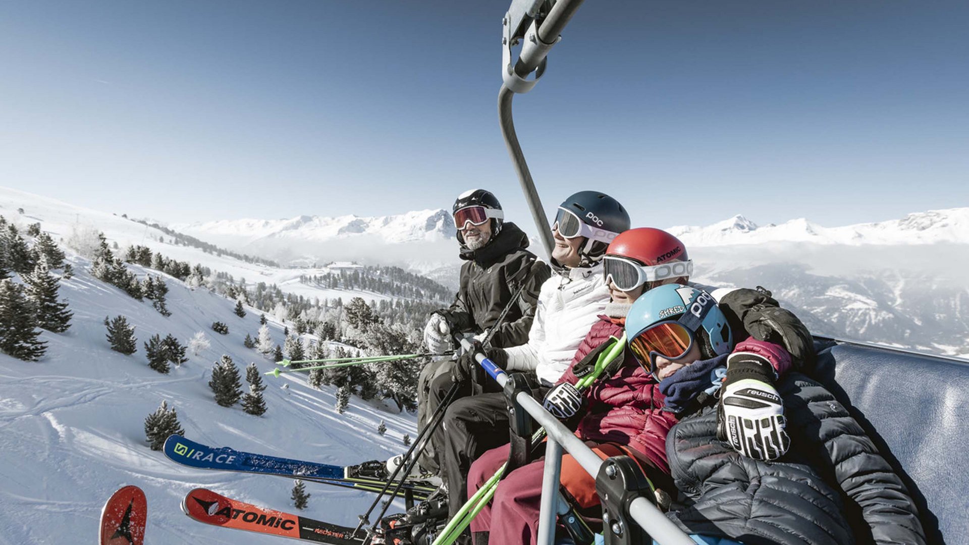 Hotel Post: Ihr Skihotel in Tirol Vier Skifahrer auf einem Sessellift über verschneiter Berglandschaft