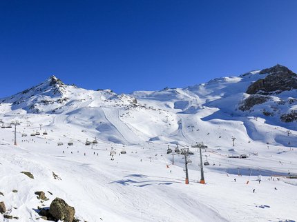 Ihr Hotel in unmittelbarer Nähe von Serfaus-Fiss-Ladis Skiresort mit Sesselliften und Skifahrern an sonnigem Wintertag