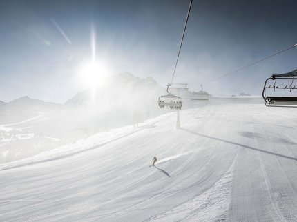 Winterurlaub in Tirol – Skispaß & Entspannung in den Alpen Skiort mit Skilift und sonnigem, nebligem Winterhang