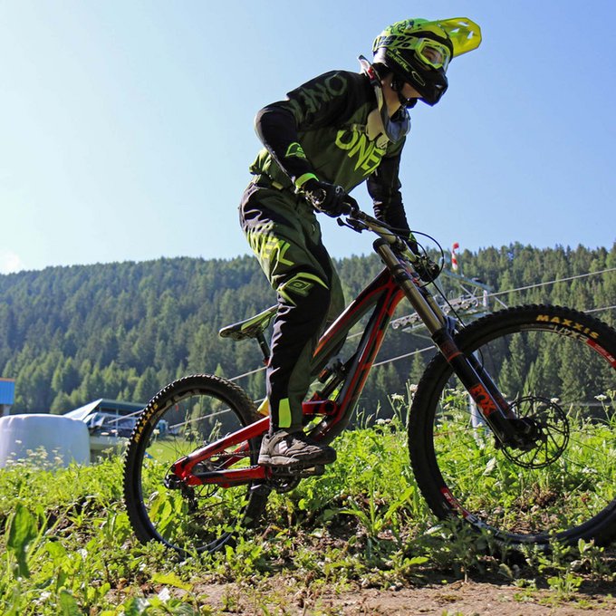 Ihr Radurlaub in Österreich/Tirol Mountainbiker mit Helm fährt bergauf auf einem Trail im Wald