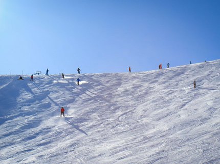 Hotel Post: Ihr Skihotel in Tirol Skifahrer auf schneebedecktem Hang unter klarem blauem Himmel