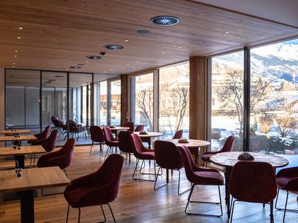 Alpine Kulinarik in Prutz Modernes Café mit Holzboden und großen Fenstern mit Bergblick im Winter