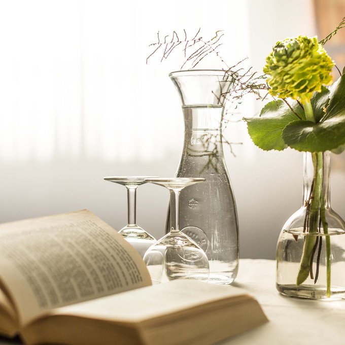 Ihre Unterkunft in Prutz Offenes Buch, zwei Weingläser, Karaffe und Blumen in Vase auf hellem Tisch