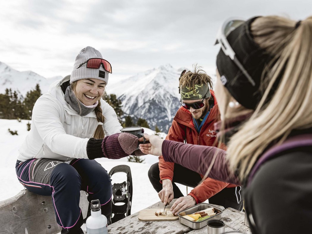 Beat the winter blues with winter magic. Friends taking a winter break eating and drinking in the snowy mountains