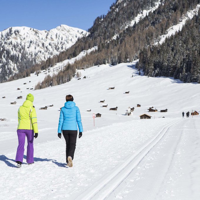 Winter hiking trails in the Tyrolean Oberland Two people walking in the snow in the mountains under clear sky